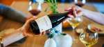 Passing a bottle of Pinot Noir