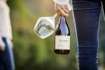 Holding a bottle of Pinot Noir